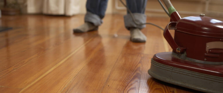 Polishing hardwood floor with scrubbing machine.