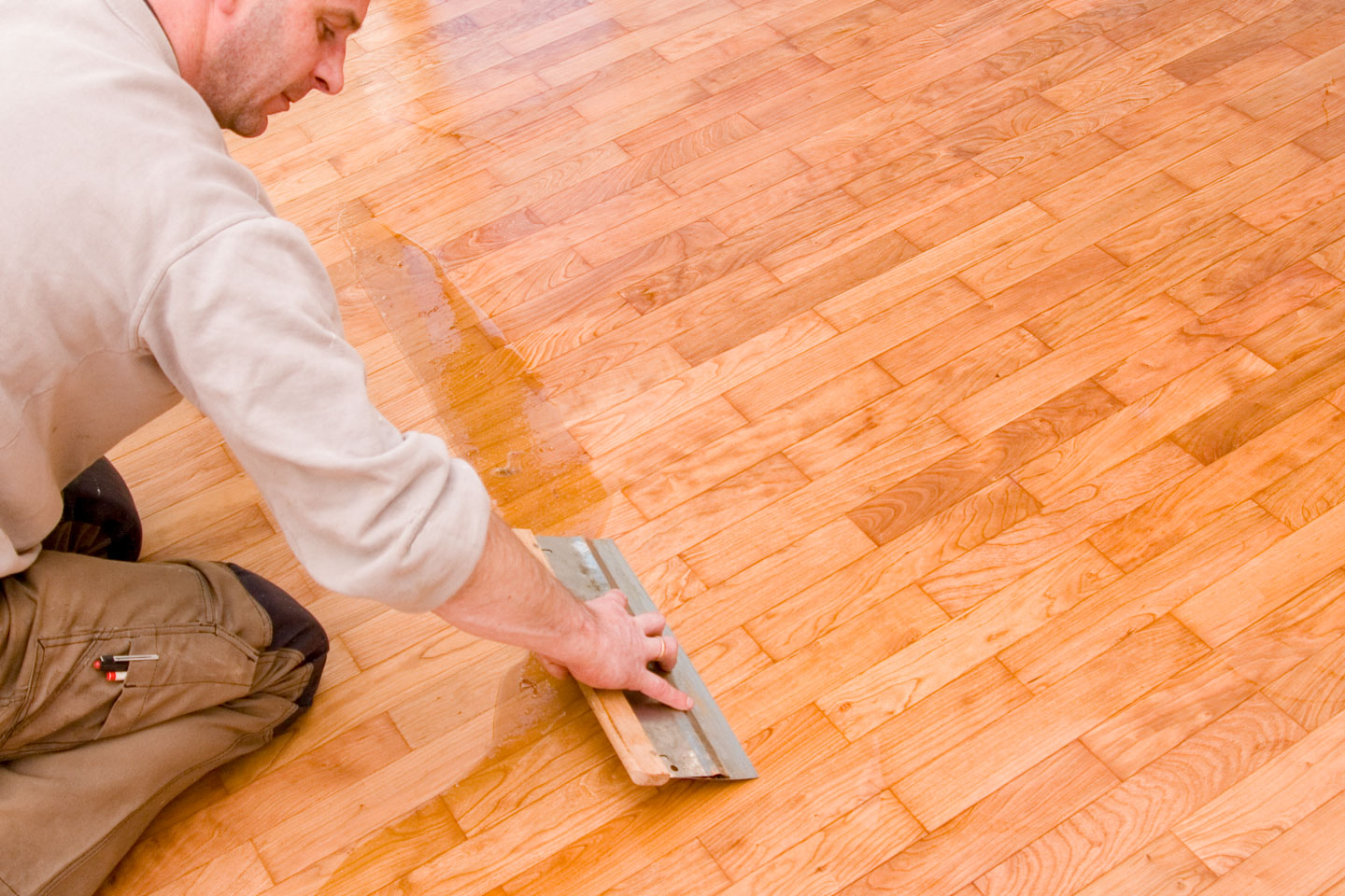 a person removing wax from hardwood floor.