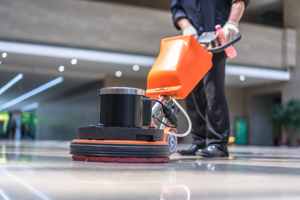 a person polishing tiles with scrubbing machine.