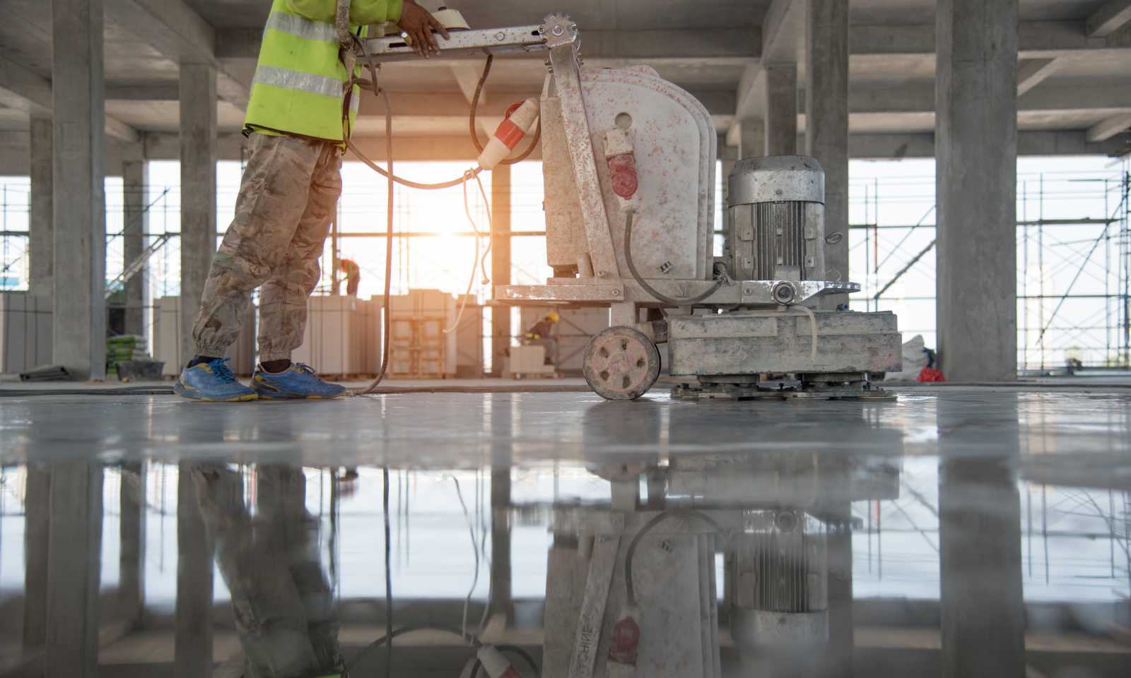 a person grinding and polishing concrete floor with a floor grinding machine.